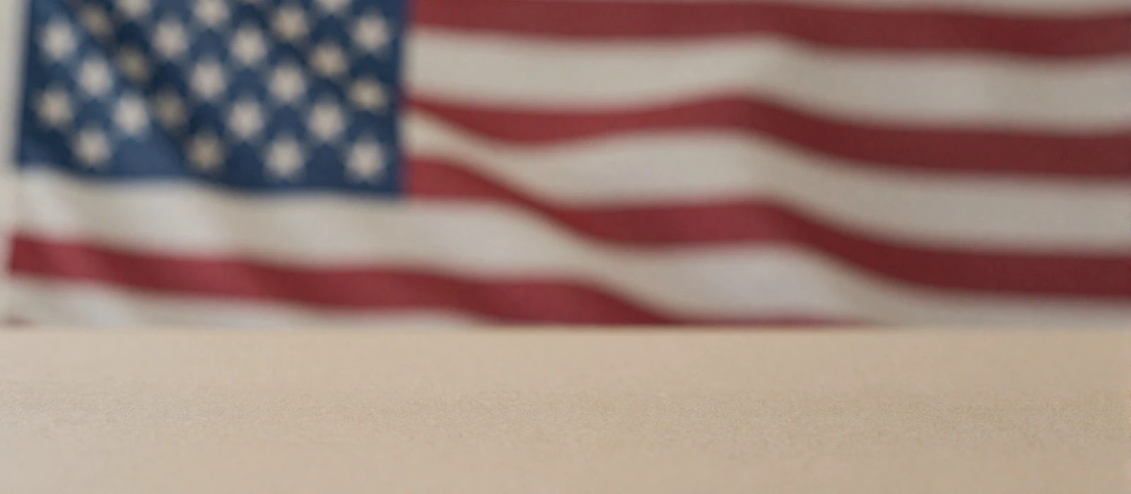 Softly blurred American flag behind a calm neutral surface, representing privacy on our patriotic military dating site