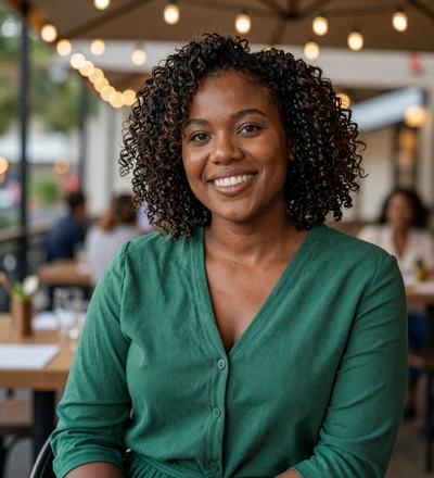 Black woman smiling on a restaurant terrace, a military singles dating member seeking a serious relationship